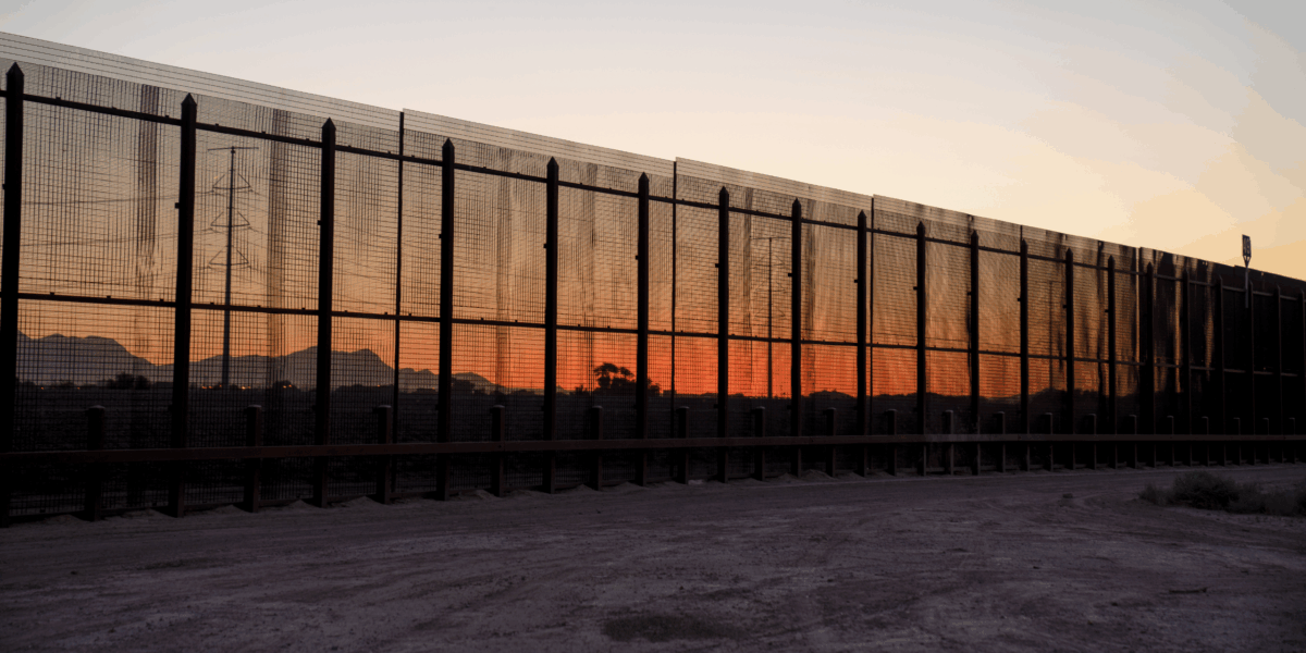 A section of the fence separating the U.S. in Mexico at sunset.